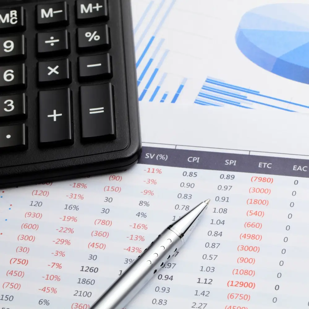 Calculator and pen on accounting report with financial charts and figures